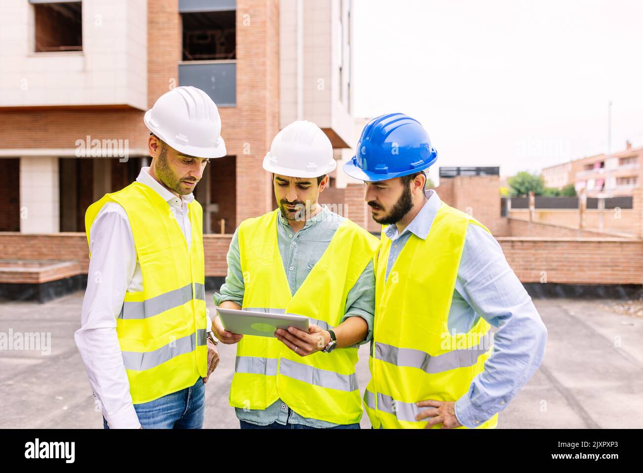 Gruppo di architetti ingegneri professionisti che discutono il piano in cantiere Foto Stock