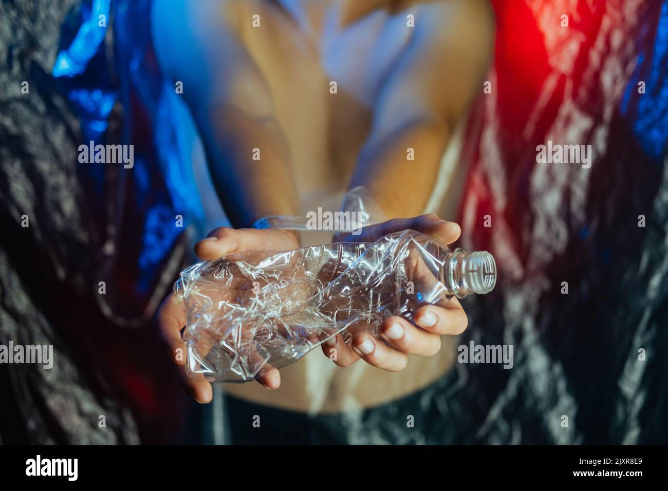 inquinamento plastico problema ecologico mani bottiglia Foto Stock