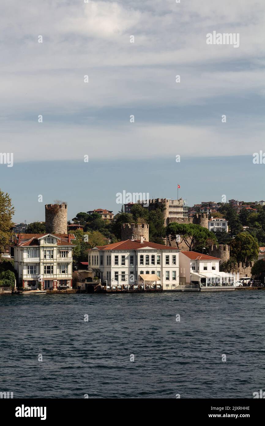 Vista delle residenze storiche e tradizionali e dell'antica fortezza anatolica sul Bosforo nella zona di Anadolu Hisari, sul lato asiatico di Istanbul. E' una suma di sole Foto Stock