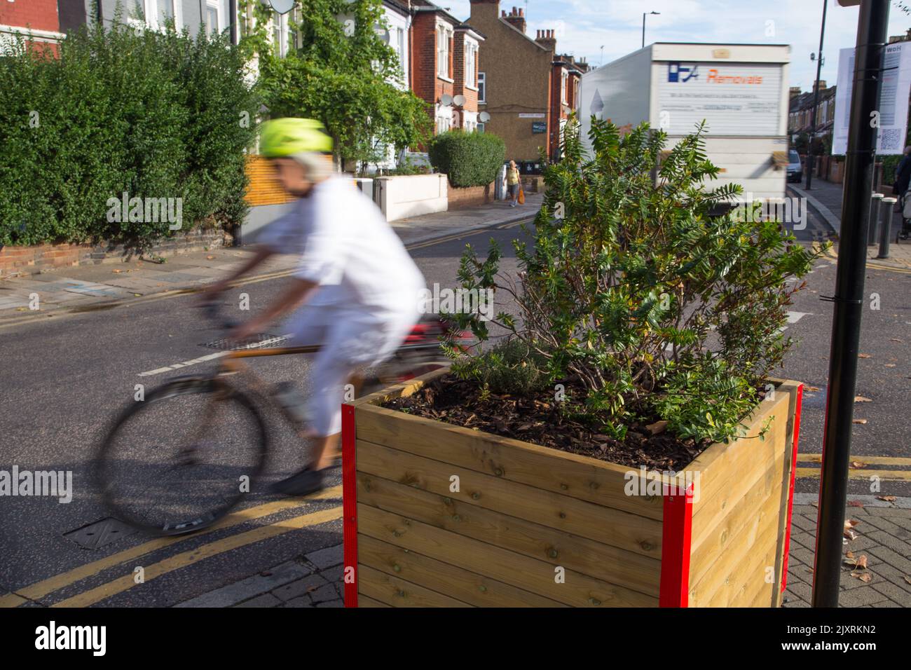 Un ciclista passa attraverso barriere che segnalano una controversa LTN (Low Traffic Neighbourhood) su Black Boy Lane nel quartiere di Haringey a Londra. Foto Stock