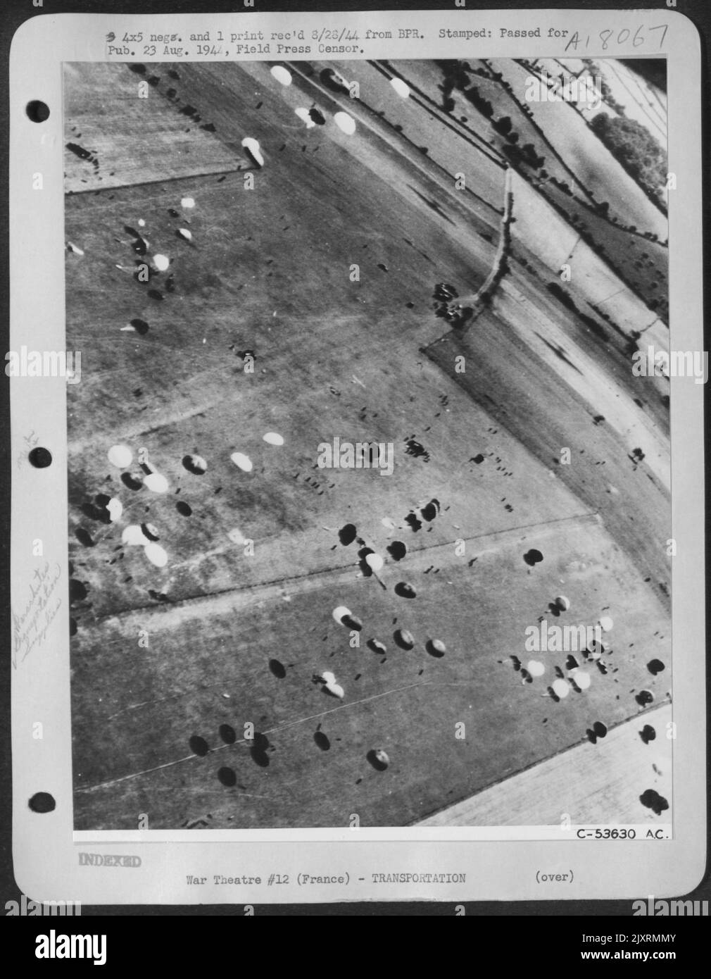 COME 8th FORTEZZE AAF RUGGITO DENTRO, GLI UOMINI DELLA MACCHIA PRECIPITARE FUORI PER RACCOGLIERE LE FORNITURE - paracadute varicolored oscillare terra, caduto dalle baie bomba dei 8th aerei pesanti bombardieri che hanno lasciato giù sopra la campagna francese cadendo vitale Foto Stock