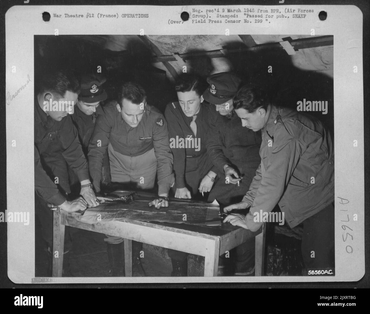Poco prima di partire per una missione fotografica ad alta quota sulla Germania, Allied Recon. I piloti del primo TAC/AF tracciano i loro percorsi su una mappa dell'area assegnata. Gli aerei U.S.A.F., R.A.F. e dell'aeronautica francese sono, da sinistra a destra: Cap. James F. Foto Stock