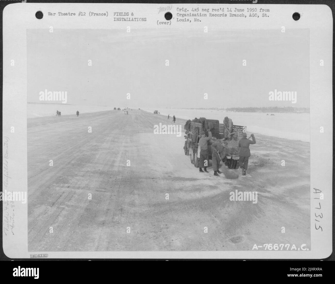 La ghiaia viene gettata sulla pista dai membri del Battaglione Aviazione Ingegnere del 834Th mentre la costruzione procede su un campo aereo a Cormeilles, Francia, nonostante Una tempesta di neve. Foto Stock
