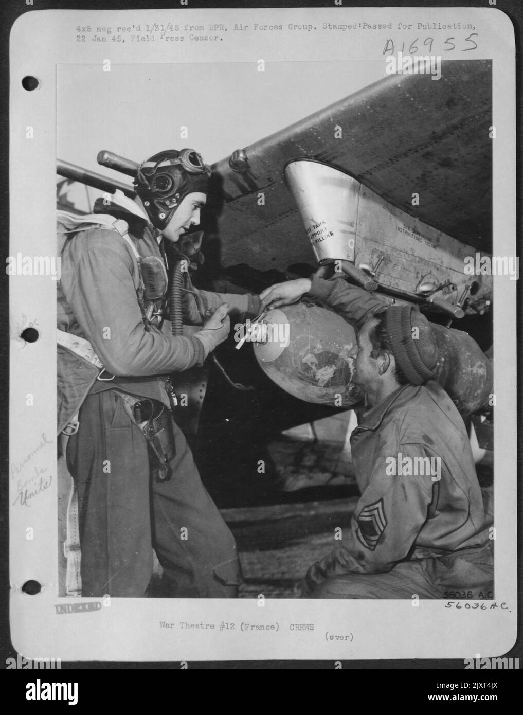 Major Gilbert F. Talbot, a sinistra, Clackamas, Oregon, un pilota del gruppo combattente-bombardiere 354th, e M/Sgt. Joseph Scruggs, Odessa, Texas, un armatore, esamina la bomba da 500 libbre sbattita sotto un'ala della Repubblica maggiore P-47 Thunderbolt a un 9th Foto Stock