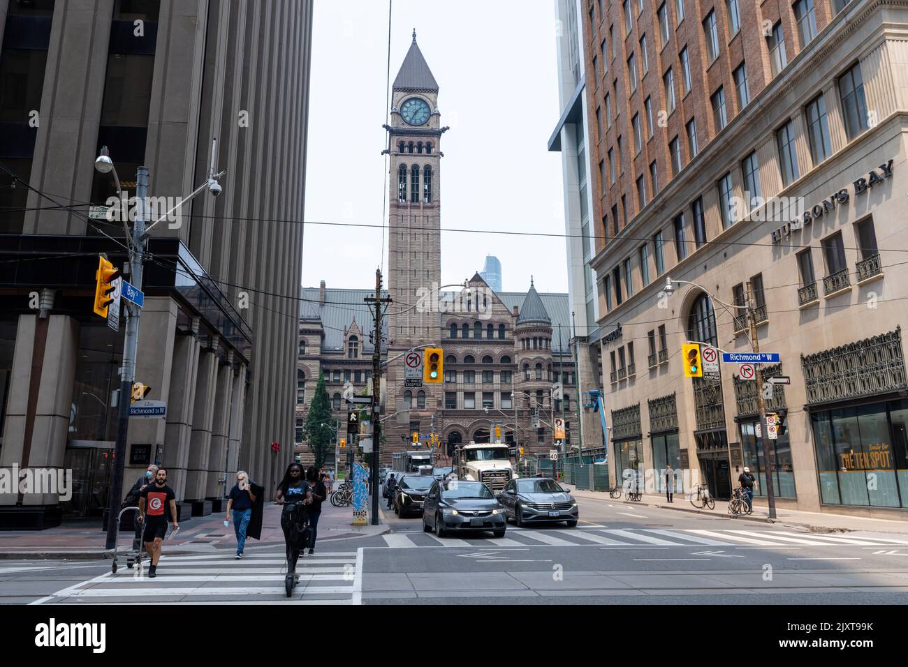 Pedoni a piedi nel quartiere finanziario del centro di Toronto. Richmond Street West, attraversamento di Bay Street. Vecchio Municipio di Toronto. Foto Stock