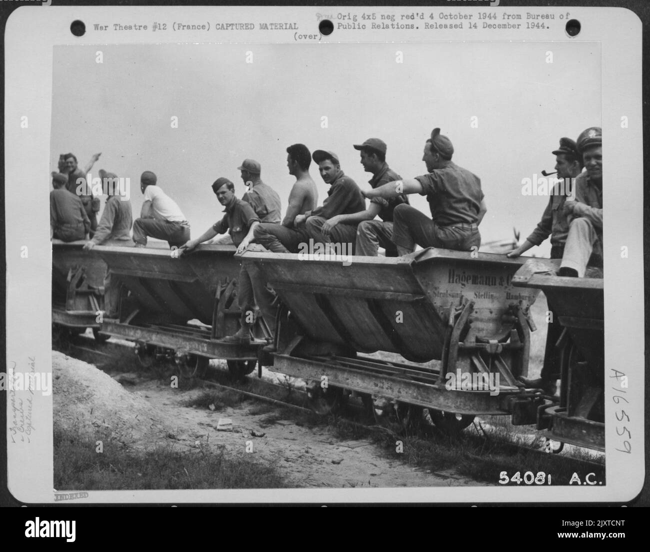 I piloti e i loro equipaggi di un gruppo di combattenti dell'aeronautica 9th fanno un giro su una piccola ferrovia catturata con un aeroporto tedesco da qualche parte in Francia. Il treno catturato è stato utilizzato per consegnare forniture, munizioni e personale a varie parti della base. Foto Stock