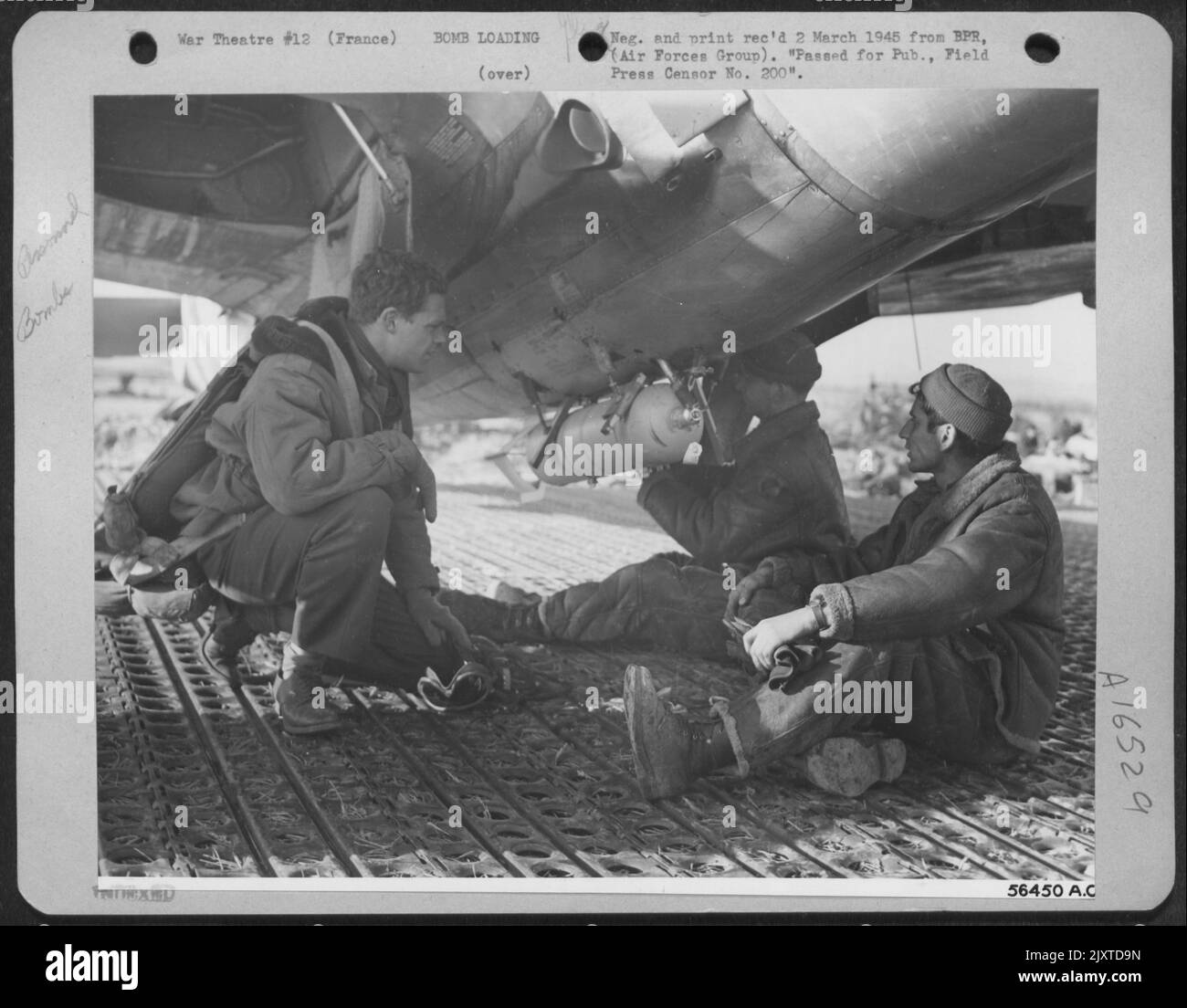 Presso una base di caccia-bombardieri del 12th Tactical Air Command in Francia, una bomba phoforous da 100 libbre è attaccata al ventre di una Repubblica P-47 Thunderbolt. Pilota, 2nd Lt. Wesly R. Izzard, 2805 Lipscord, Amarillo, Texas, a sinistra, Orologi come S/Sgt. Albert Foto Stock