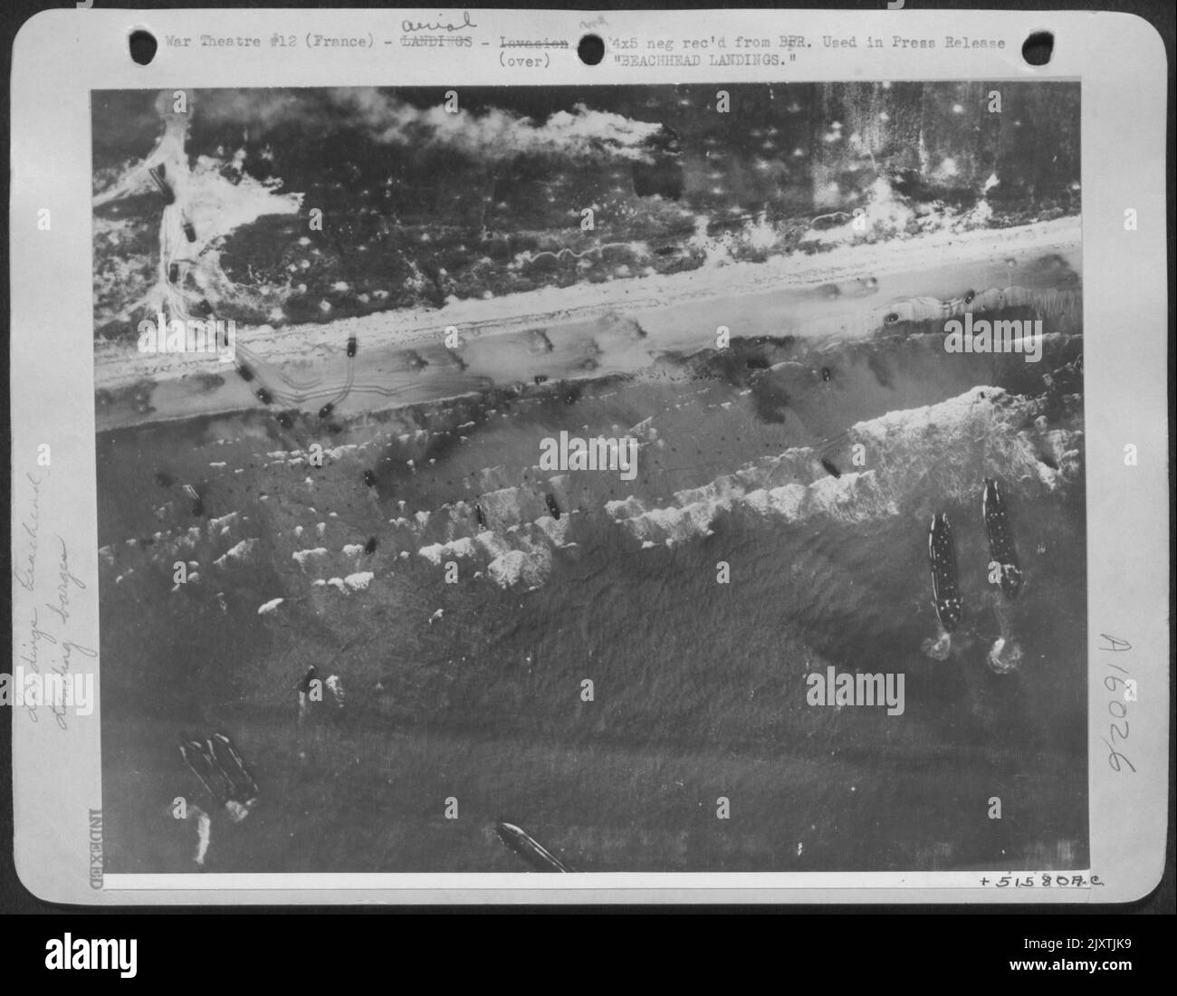 ATTERRAGGI SULLA SPIAGGIA. Uomini e veicoli d'assalto temporano le spiagge della Normandia mentre l'imbarcazione Allied Landing fa un'ammaccatura nel Muro Occidentale della Germania il 6 giugno 44. Come onda dopo onda di imbarcazioni di atterraggio scaricare il loro carico, gli uomini si muovono in avanti e i veicoli impennano Foto Stock