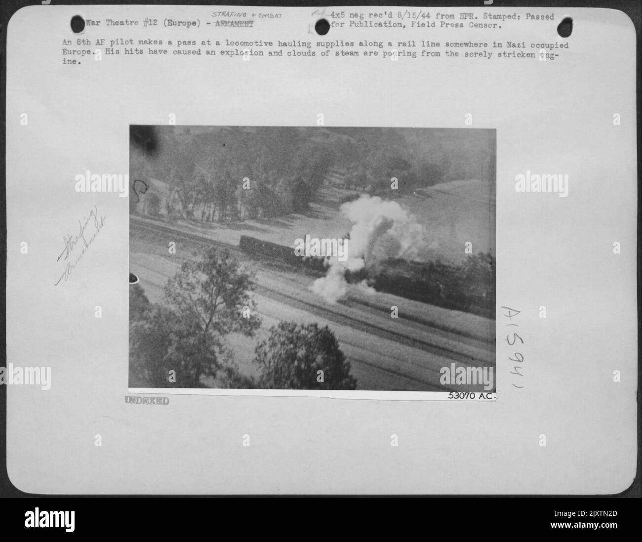 Un pilota di 8th fa un passo presso una locomotiva che trasporta rifornimenti lungo una linea ferroviaria in qualche parte dell'Europa occupata dai nazisti. I suoi colpi hanno causato un'esplosione e le nubi di vapore stanno versando dal motore colpito duramente. Foto Stock
