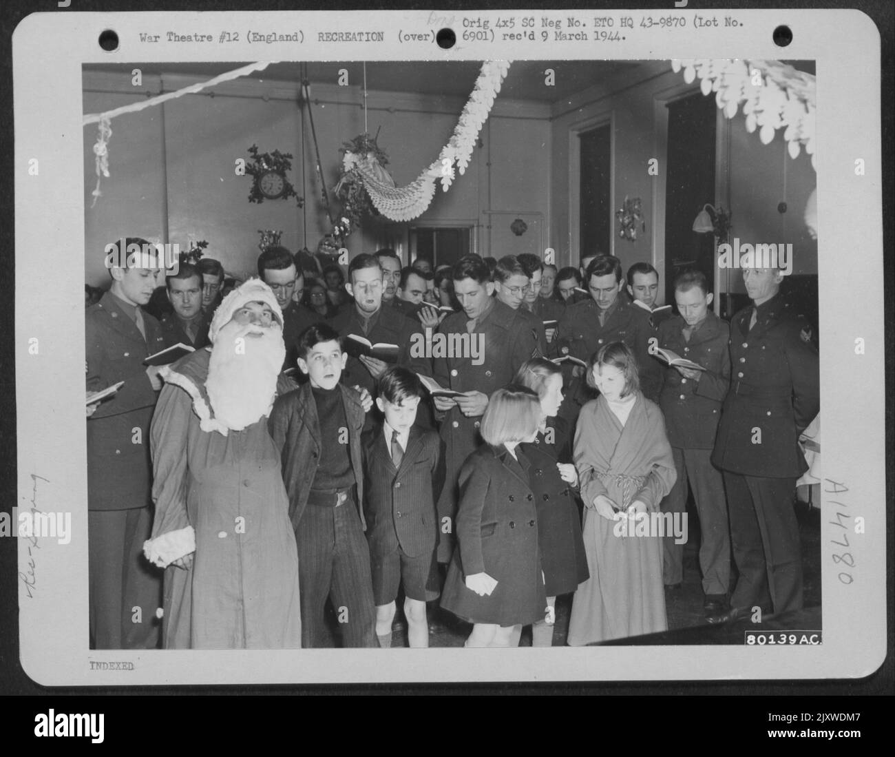 Ufficiali e arruolati uomini dell'aeronautica degli Stati Uniti Unisciti ai pazienti del bambino del Royal Victoria Hospital a Bournemouth, Inghilterra in canto Natale Carols durante Un partito dato dal GIS il 24 dicembre 1943. Foto Stock
