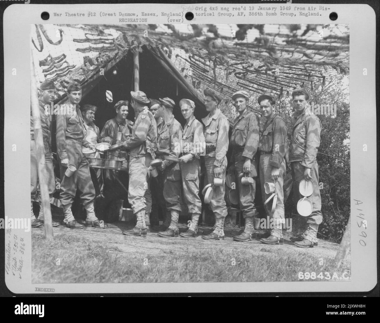 Men of Co. D Det., 555Th Signal Air Wing, 386th Bomb Group Stand in Line e aspettano il loro turno di essere serviti da personale Mess alla loro base a Great Dunmow, Essex, Inghilterra il 8 maggio 1944. Foto Stock