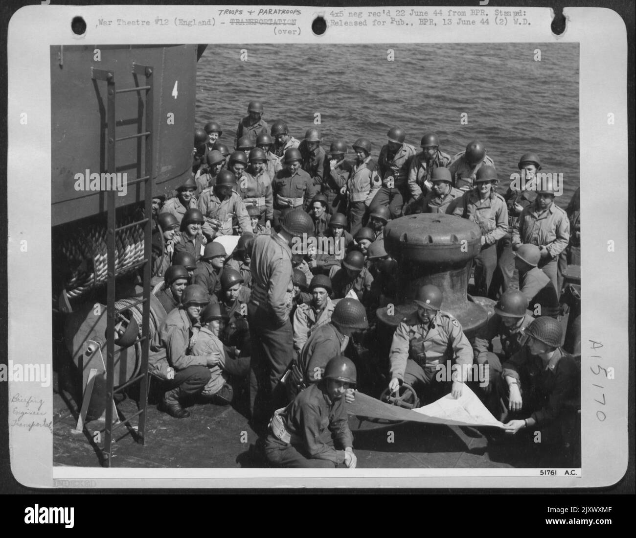 Seduto davanti a un cabestano a bordo di una LST, il Lt. Col. John J. Livingston di Cedar Hill, Mo., fornisce i briefing degli ultimi minuti ai suoi uomini, tutti i membri di un Battaglione di Aviazione dell'Ingegnere dell'Aeronautica militare 9th, prima dell'assalto iniziale del D-Day. Questi Foto Stock