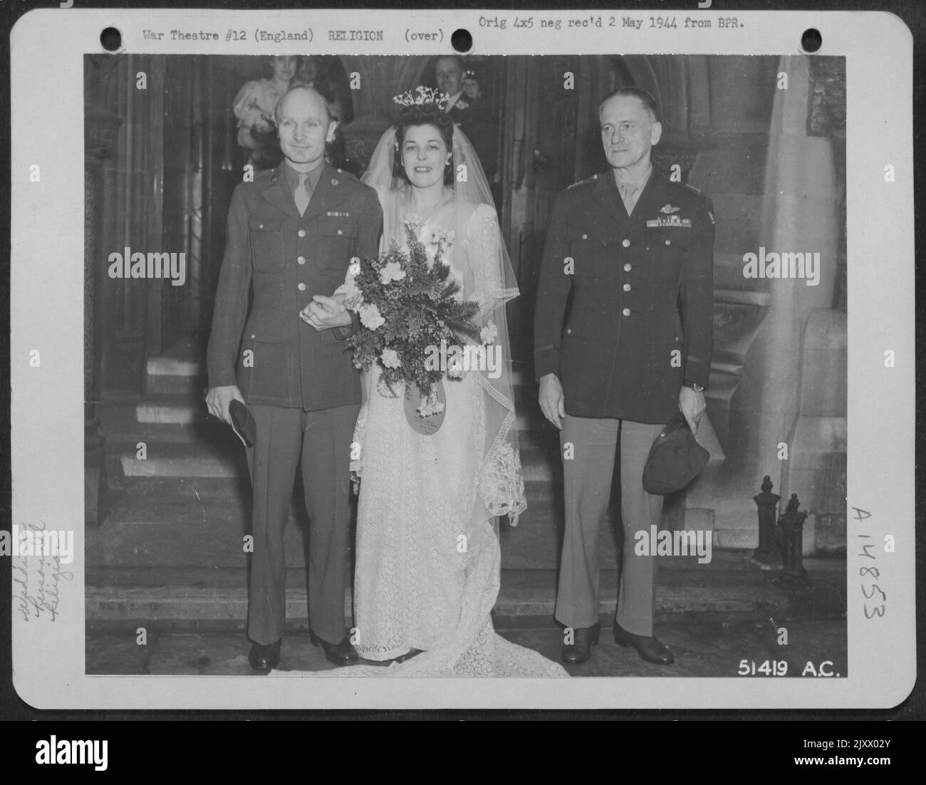 Il generale Carl Spaatz posa davanti alla chiesa della Santissima Trinità a Londra, Inghilterra con M/Sgt. Thomas Isabel e la sua sposa, la signorina Joyce Kelly, dopo essere stati sposati il 17 aprile 1944. SGT. Isabel, la cui casa si trova a Earl, Arkansas, è l'autista di Gen. Spaatz Foto Stock