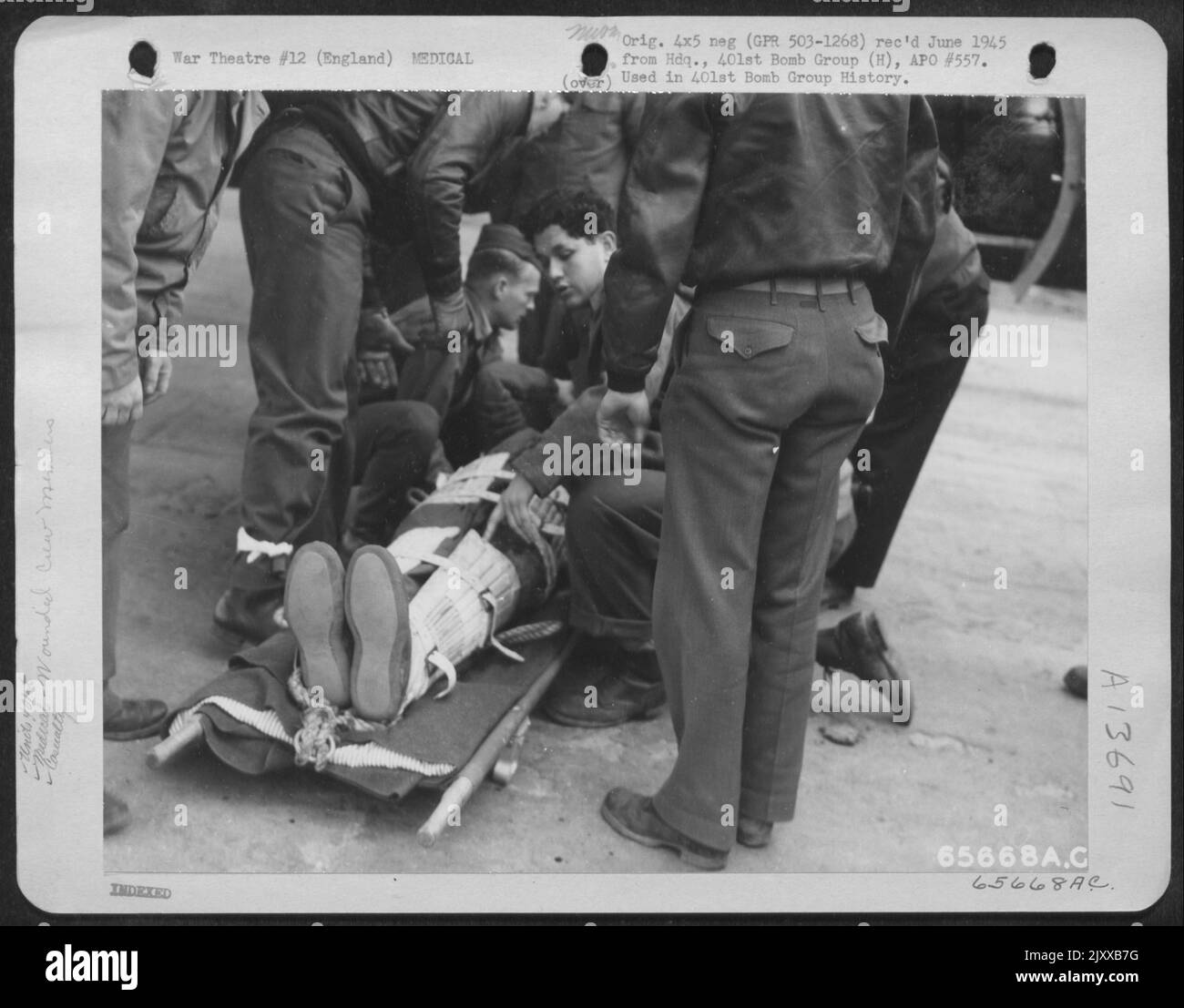 Ecco Una triste testimonianza del trite verismo che quando le guerre sono combattute gli uomini devono sanguinarsi e morire. Un membro dell'equipaggio ferito del Gruppo bomba del 401St viene collocato su Uno Stretcher per il trasferimento a Un'ambulanza in attesa presso una base dell'aeronautica militare del 8th in Inghilterra. 12 aprile 1944. Foto Stock