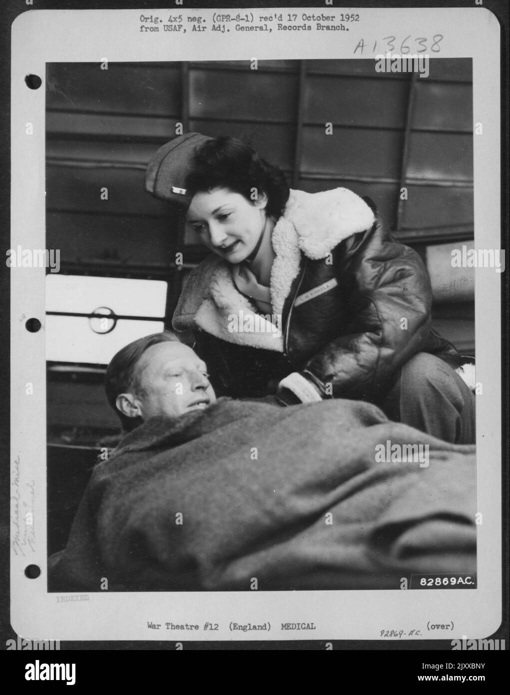 1st Lillian M. Kinkila di Richmond, California, infermiera di volo del comando carrier della truppa del 9th comforta Un paziente ferito a bordo di un aereo di evacuazione da qualche parte in Inghilterra. Foto Stock