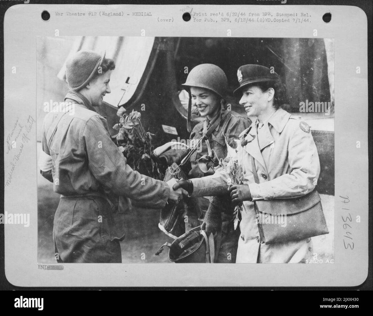 Papaveri di Francia-2nd la suella Bernard sorride e scuote le mani con il Lt. Ofster, infermiera, mentre il 2nd la Mary Jane Brown di Columbus, Ohio, guarda. Nurse Brown ha portato papaveri insieme con feriti da una testa di spiaggia in Normandia. Foto Stock