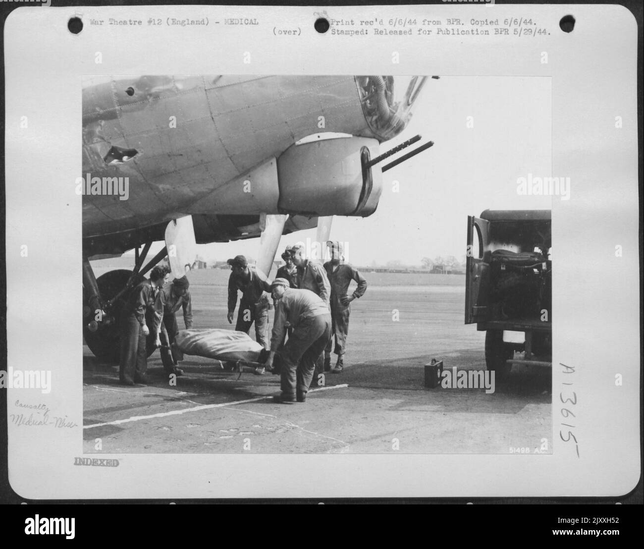 Alcuni uomini tornano a casa morti. Il navigatore di questa ofrtress volante, appena tornato da Merseburg, fu ucciso da un flak che entrò attraverso il fianco della nave. Notare il buco flak sulla nave. Medici e infermieri di volo in questa US Army 8th Air Foto Stock