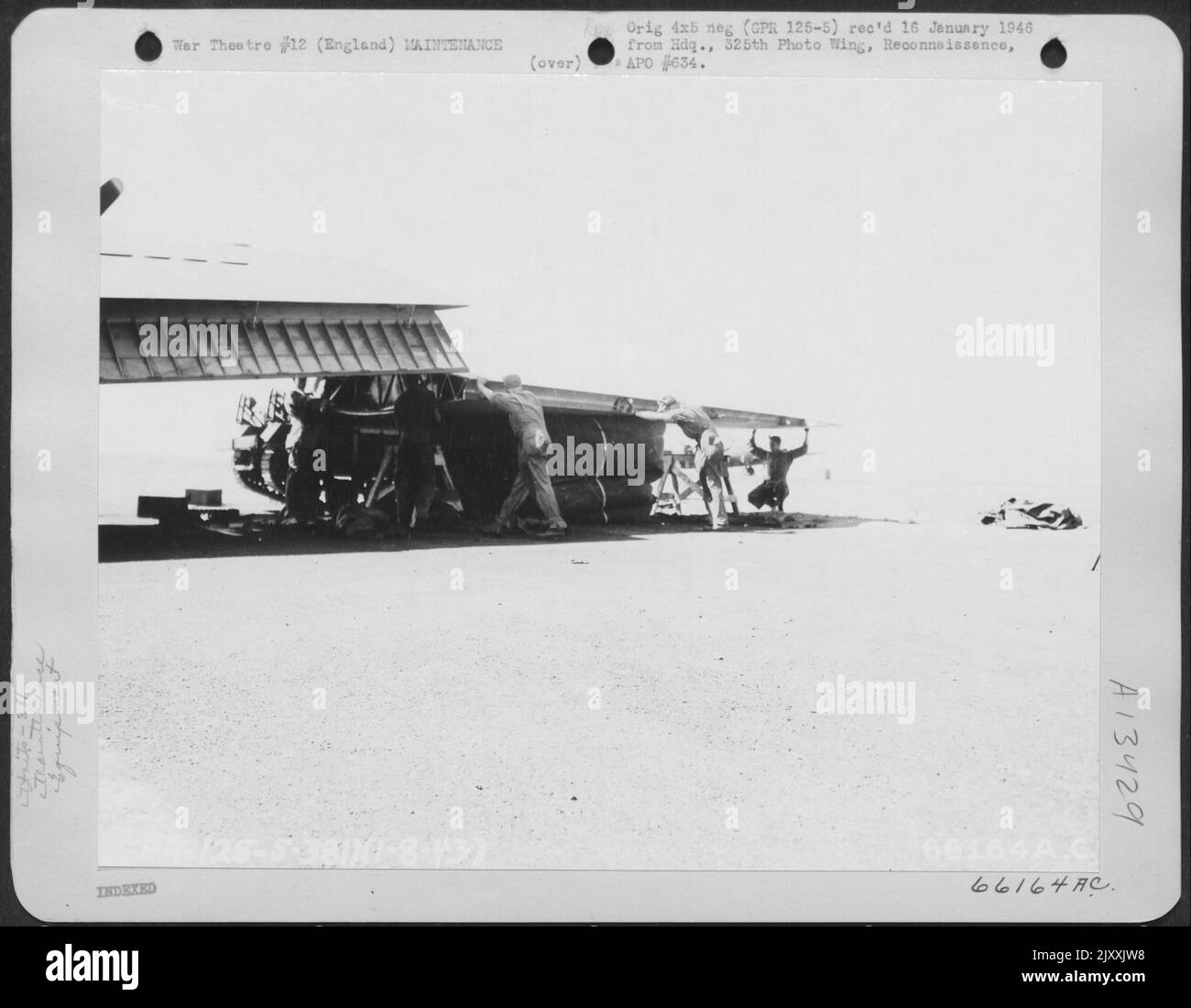 I membri del gruppo bomba 381st utilizzano Un cuscino pneumatico per sollevare la sezione alare in posizione di Una fortezza volante Boeing B-17. Inghilterra, 1 agosto 1943. Foto Stock