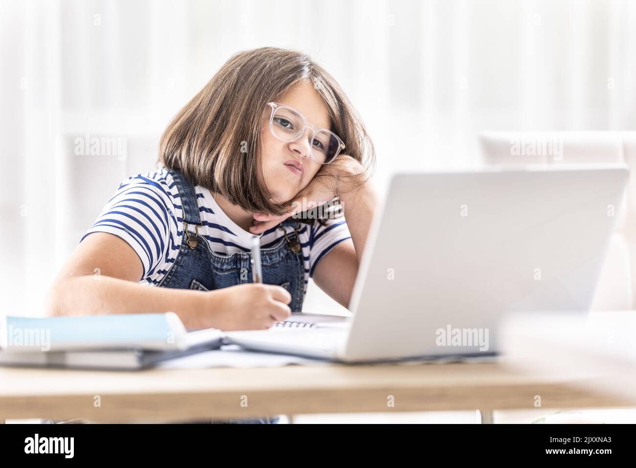 Imparare a distanza non appena l'umore di una giovane scolaretta che studia da casa. Foto Stock