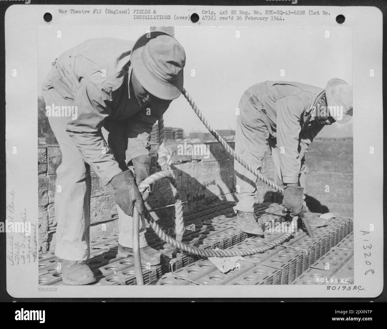 I membri del 434Th Engineering Detachment Pick Up Landing Mats con Landing Mat Hooks all'ippodromo di Newbury, Berks, Inghilterra. 24 agosto 1943. Foto Stock