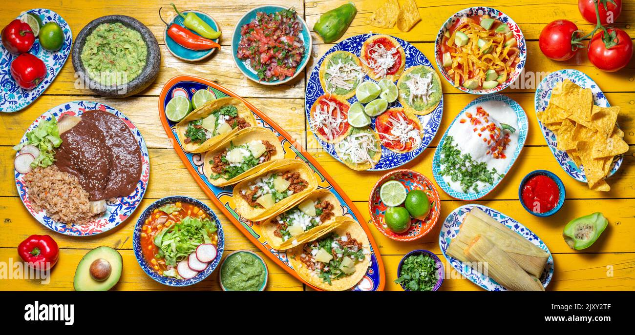 Cibo messicano festivo per il giorno dell'indipendenza - independencia peperoncini en nogada, tacos al pastor, chalupas pozole, tamales, pollo con salsa di poblano talpa Foto Stock