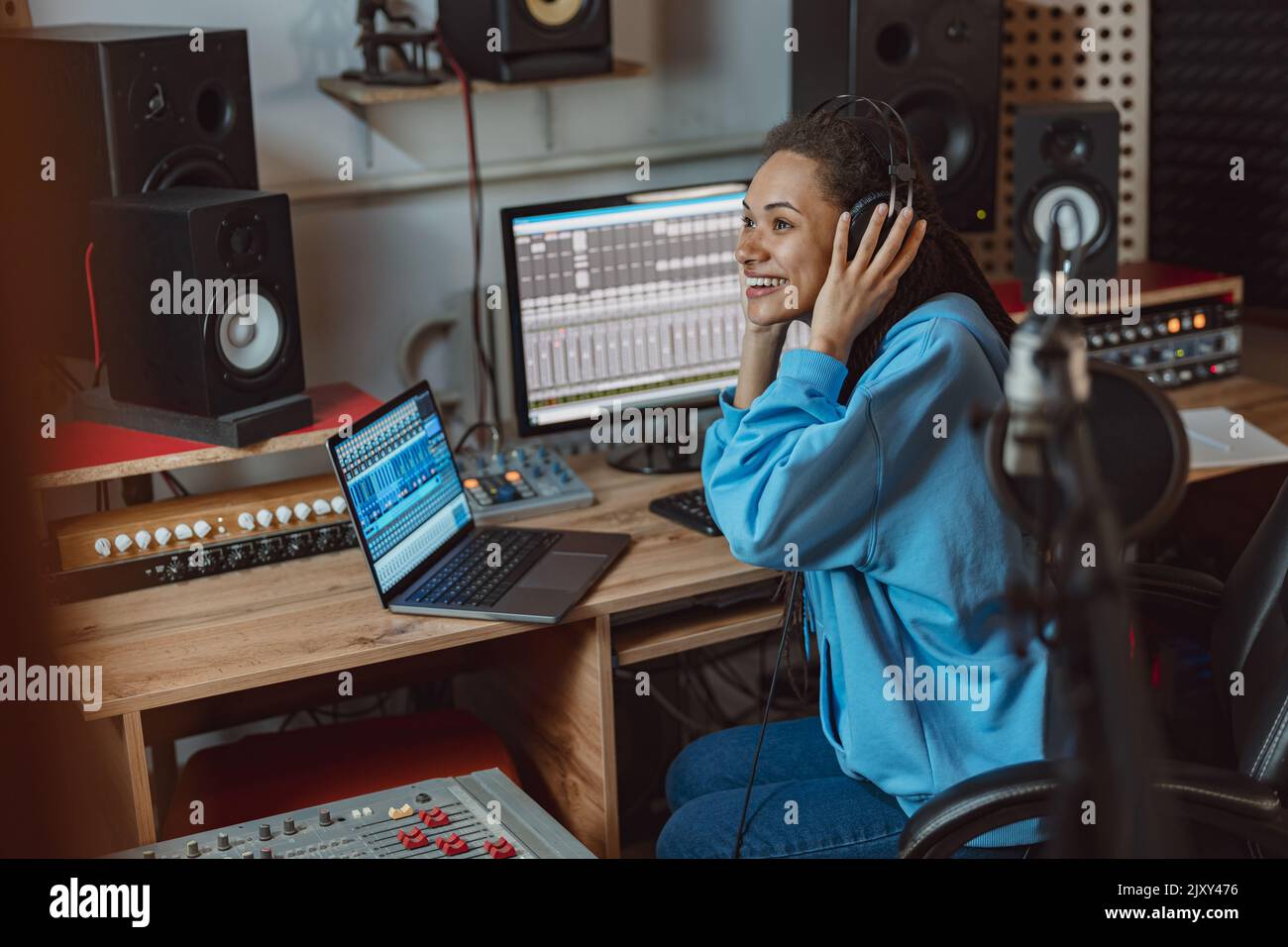 Bel presentatore radiofonico afroamericano che lavora in uno studio di trasmissione radiofonica che parla con gli ascoltatori Foto Stock
