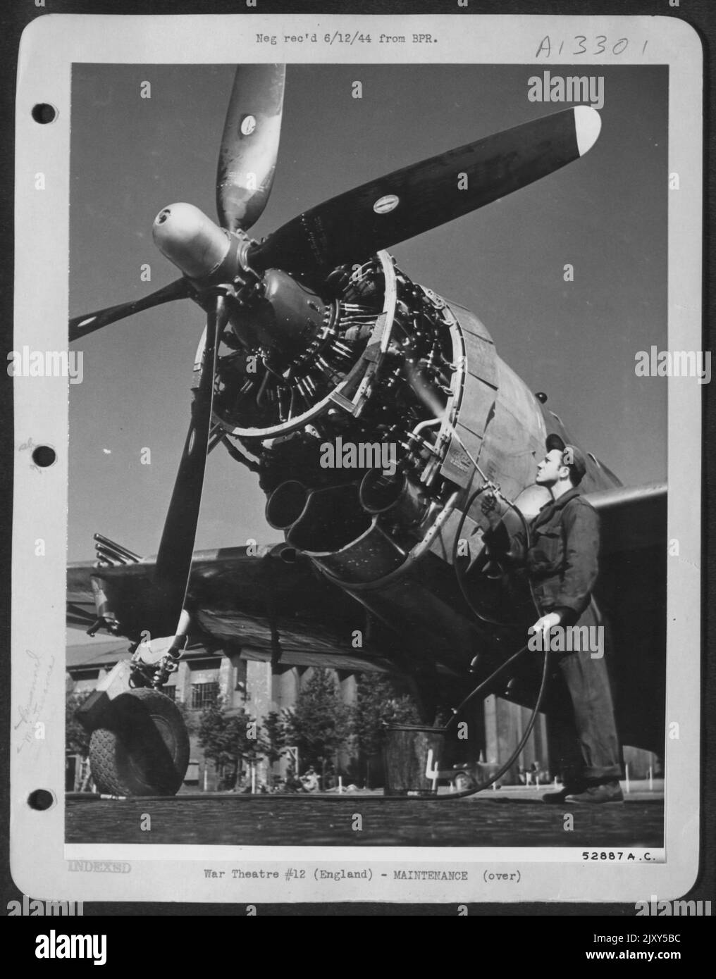 SGT. William Trickey, capo equipaggio, gioca a benzina spray sul motore di Republic P-47 Thunderbolt per lavare gli accumuli di olio e grasso prima di sostituire il cofano motore. L'aereo, uno dei più nuovi arrivi, pilotato da Major Ebey, Group Operations Foto Stock