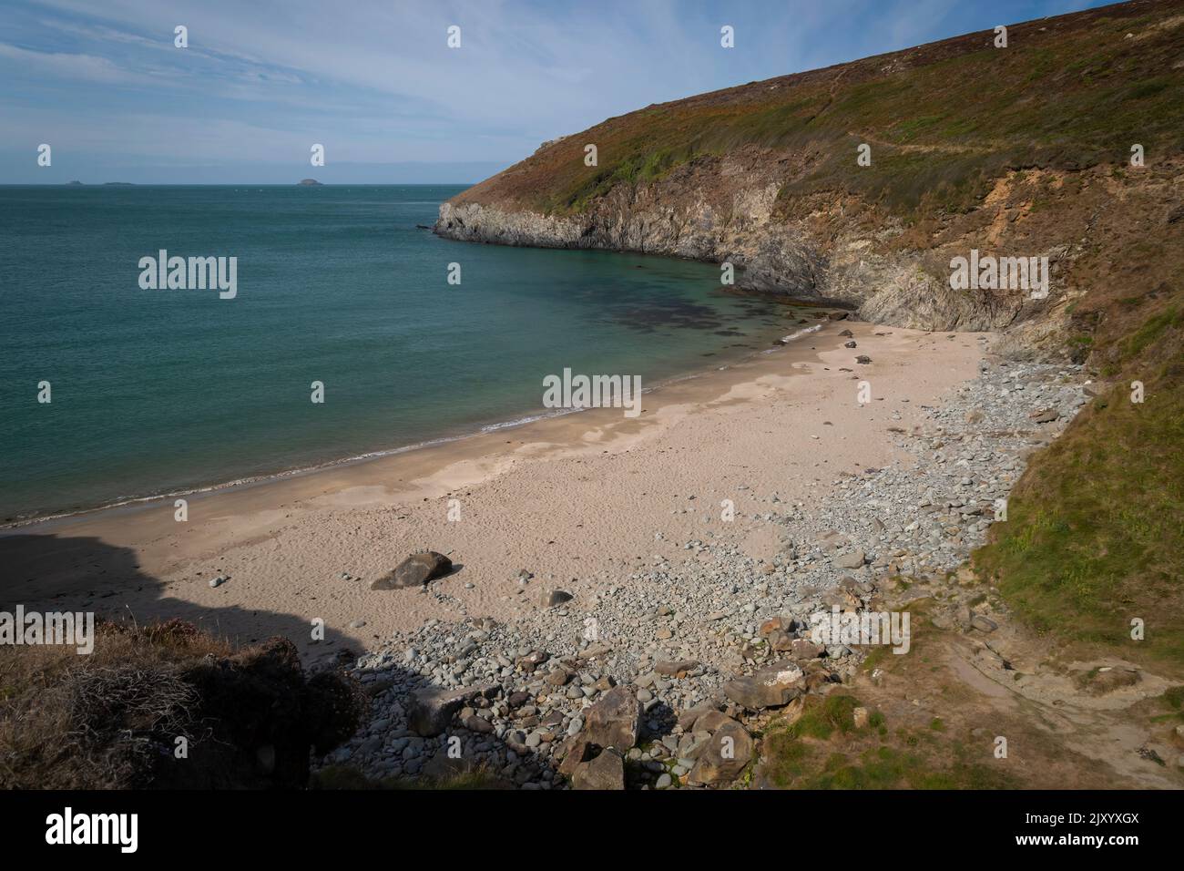 Una piccola insenatura di sabbia circondata da scogliere nel Galles occidentale, nel Regno Unito, appena a nord di Whitesands Bay, accessibile solo a piedi. Foto Stock