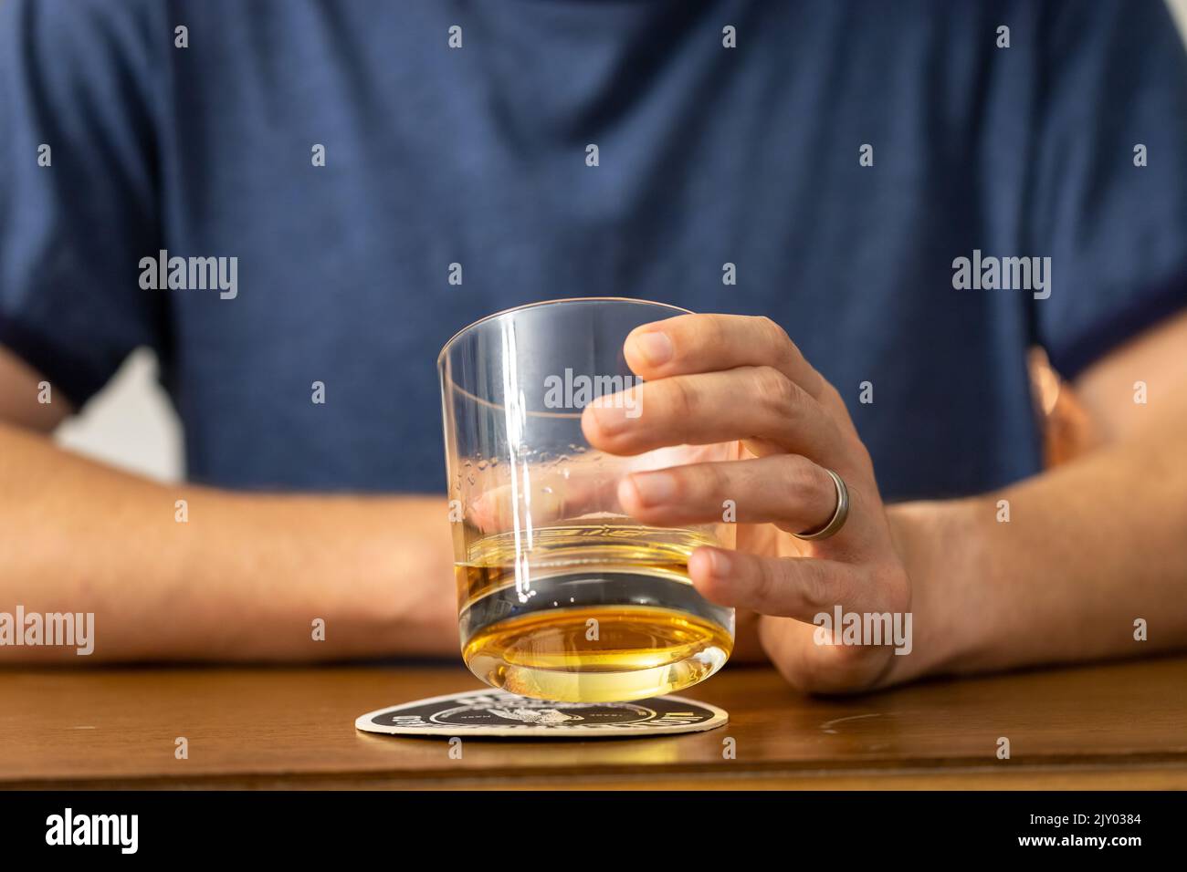 Uomo che beve un bicchiere di whisky in un bar Foto Stock