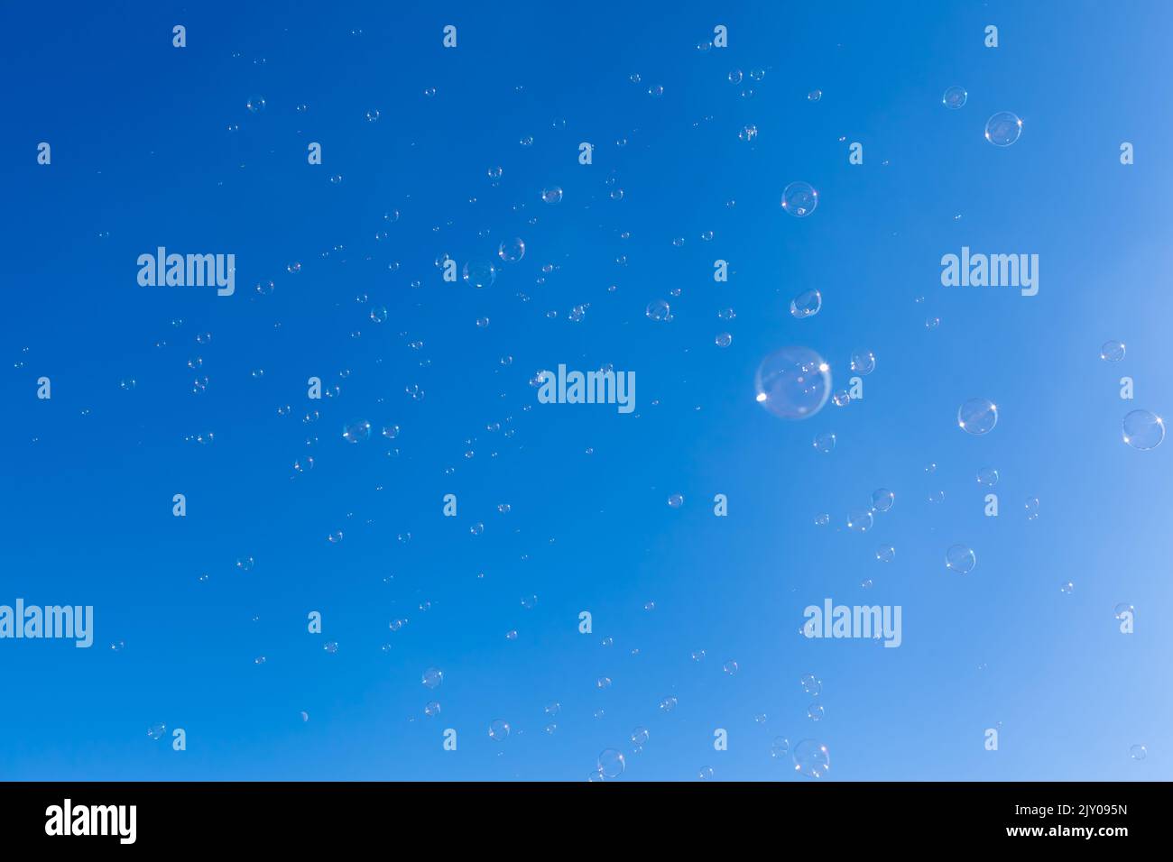 Molte bolle di sapone galleggiano al cielo blu Foto Stock