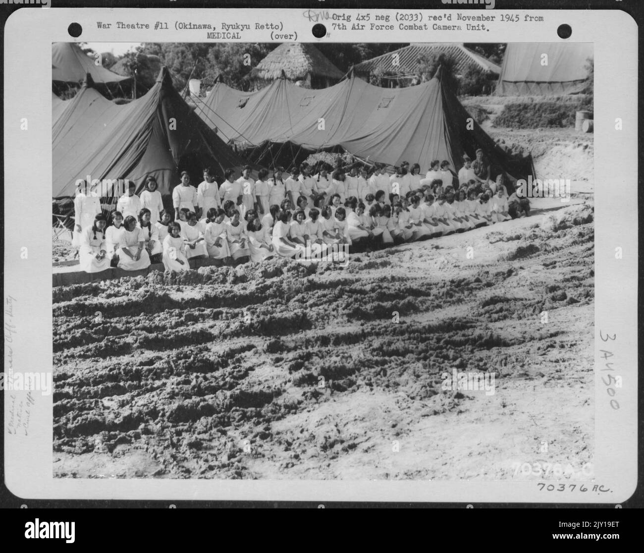 Gli indigeni di Okinawa, addestrati come Corpsmen, sono aiutati come infermieri in tutto l'ospedale militare americano di governo a Okinawa, Ryukyu Resto. 15 giugno 1945. Foto Stock
