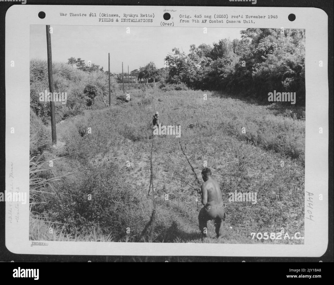 I cavi di comunicazione sono disposti tra i poli preparatori alla giunzione e al sollevamento. Questo lavoro è stato fatto da Men del 443Rd Signal Heavy Construction Battaglione a Okinawa, Ryukyu Rett, luglio 1945. Uno dei primi lavori del Battaglione fu ricostruire e se Foto Stock