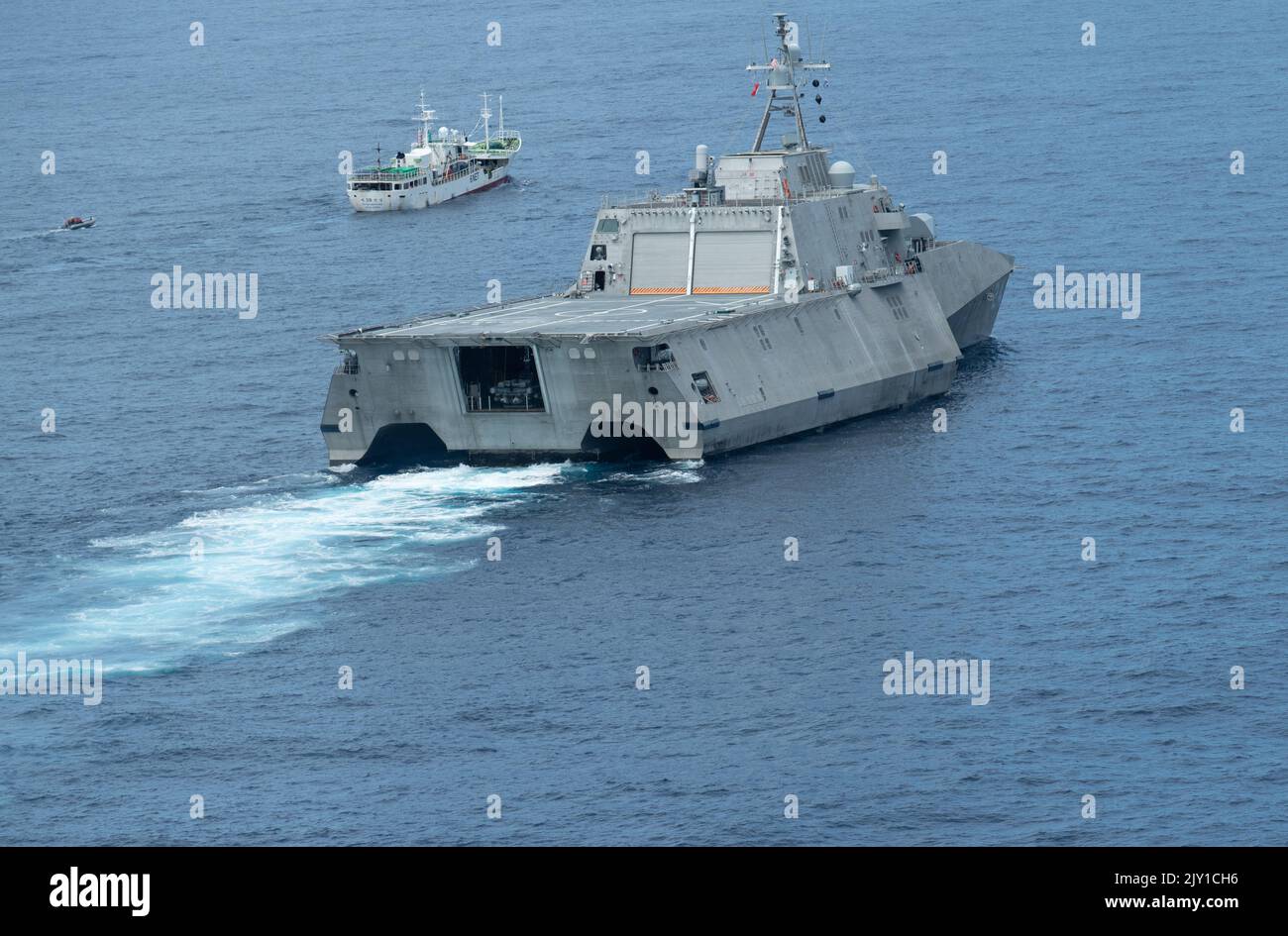 Nave litoranea indipendente variante USS Oakland (LCS 24) stazioni dietro una nave da pesca, mentre Tactical Law Enforcement Team Pacific Coast Guardsmen condurre un Oceania Maritime Support Initiative (OMSI) nave di conformità imbarco, 19 agosto 2022. Oakland è schierato a sostegno della Oceania Maritime Support Initiative, un programma di segretaria della difesa che sfrutta i beni del Dipartimento della Difesa in transito nella regione per aumentare la consapevolezza dei domini marittimi della Guardia Costiera e le operazioni di applicazione della legge in Oceania. (STATI UNITI Foto Navy di Mass Communication Specialist 2nd Classe Ian Zagrocki) Foto Stock