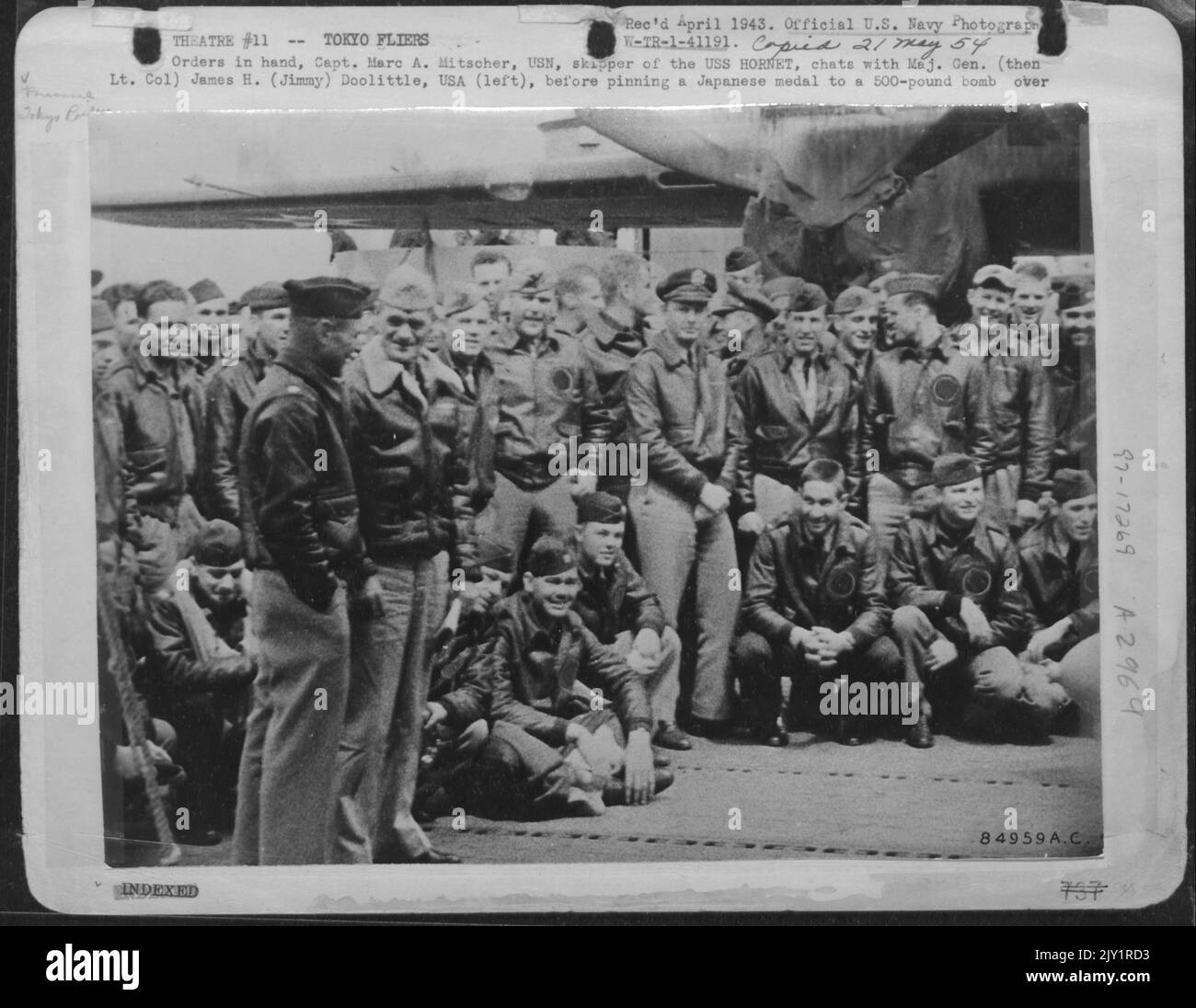 Ordini in mano, Capt. Marc A. Mitscher, USN, Skipper della USS Hornet, Chat con il maggiore Generale (poi Lt. Colonel) James H. (Jimmy) Doolittle, USA (sinistra), prima di Pinning Una medaglia giapponese ad Una bomba da 500 sterline diretta a Tokyo. Più di Un punteggio del 80 Foto Stock