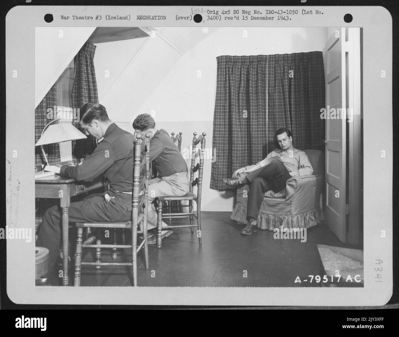 La sala di scrittura dell'Hotel De Gink, Un centro di riposo per le forze aeree a Keflavik, Islanda, è spesso utilizzata dagli uomini durante il loro soggiorno. Posti a sedere alle scrivanie sono 2nd Lt. Robert E. Krofb e Capt. Neale E. Baker e seduti nella poltrona Reading I. Foto Stock