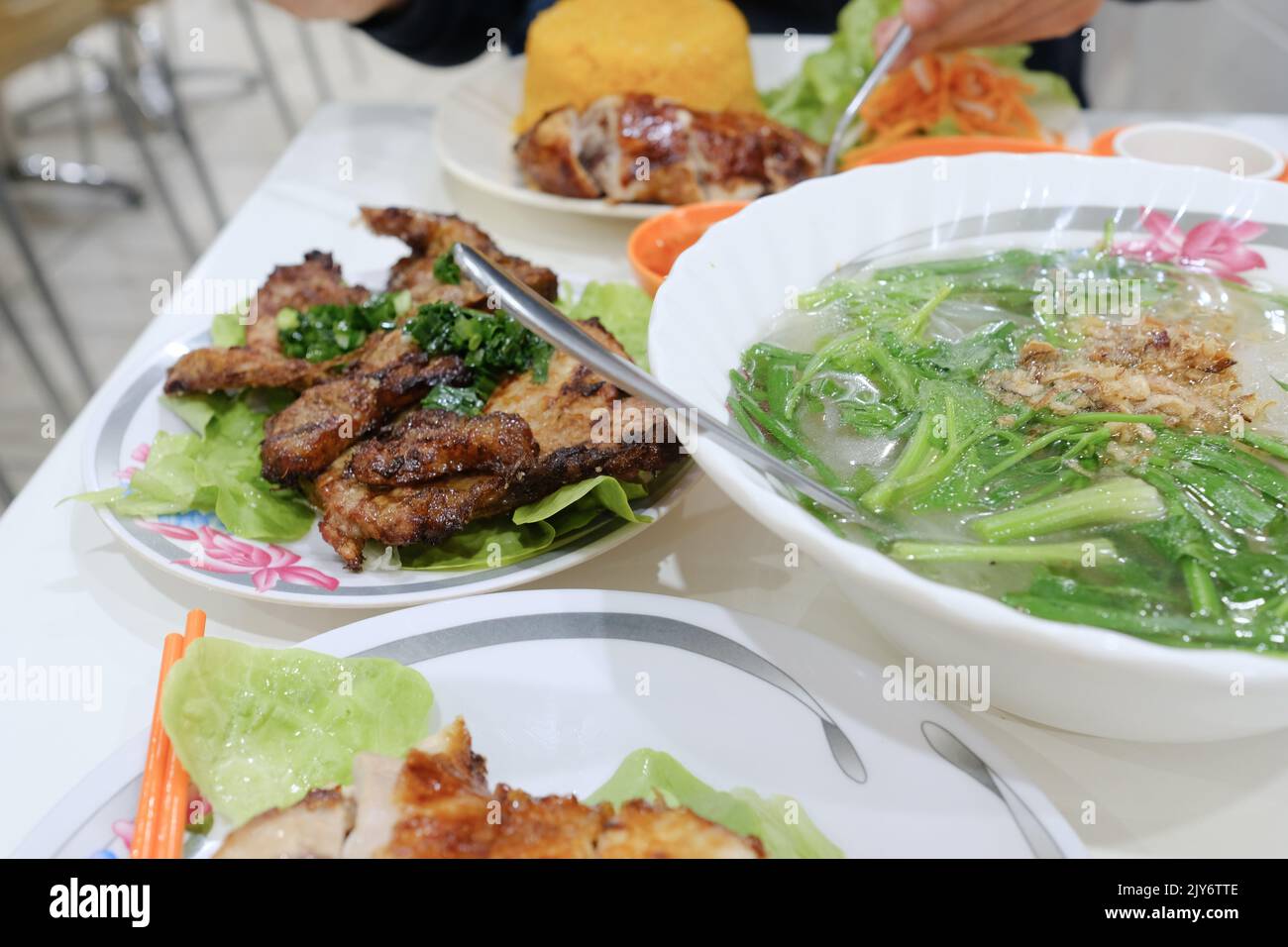 Costolette di maiale alla griglia con spaghetti di riso e pollo croccante con riso al pomodoro al Gia Hoi, un ristorante vietnamita a Bankstown, Sydney, Australia Foto Stock