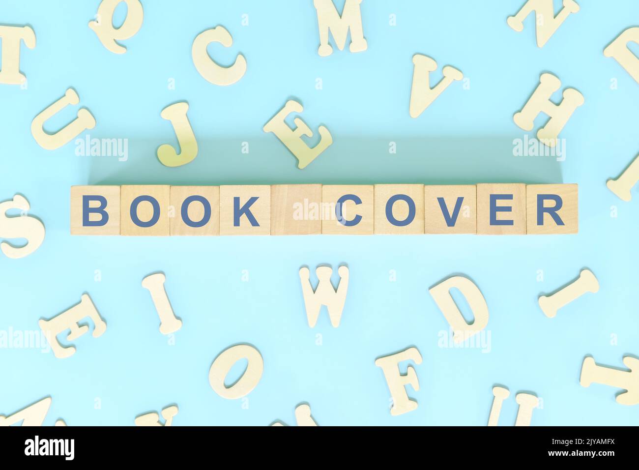 Copertina del libro parte di un concetto di libro. Blocchi di legno tipografia parola piatta giaceva su sfondo blu. Foto Stock
