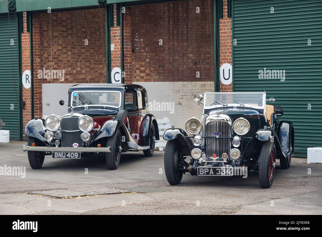 1935 Alvis e 1933 Lagonda al Bicester Heritage Centre. Oxfordshire, Inghilterra. Filtro vintage applicato Foto Stock