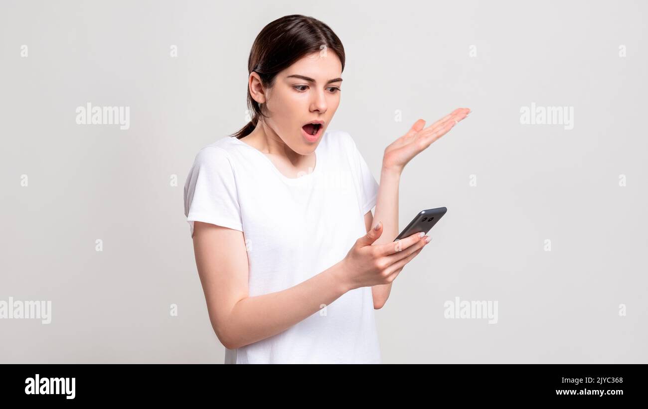 scioccato donna ritratto schiacciante telefono delle notizie Foto Stock