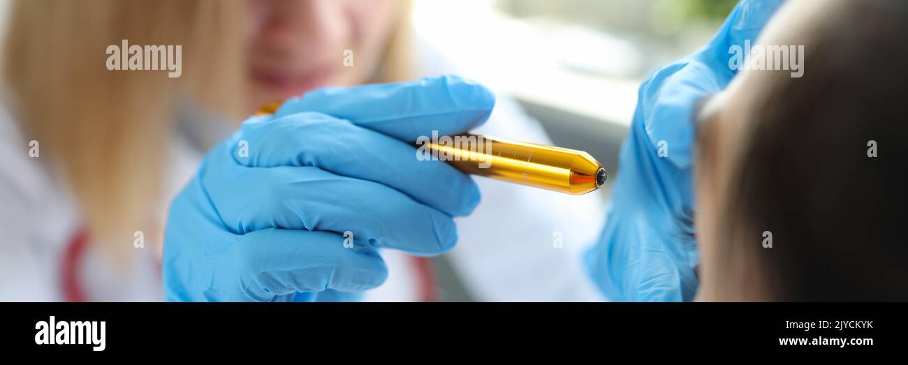 Il medico oftalmologo illumina gli occhi del paziente Foto Stock