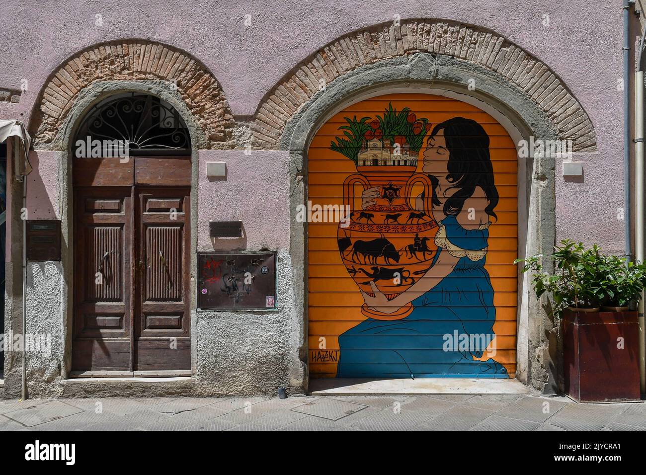 Cancello abbassato decorato con un'opera di Street art durante la manifestazione artistica 'Trame' nel centro storico di Grosseto, Toscana, Italia Foto Stock