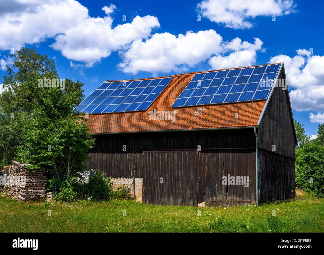 Energia Verde con collettori solari sul tetto di un edificio agricolo Foto Stock