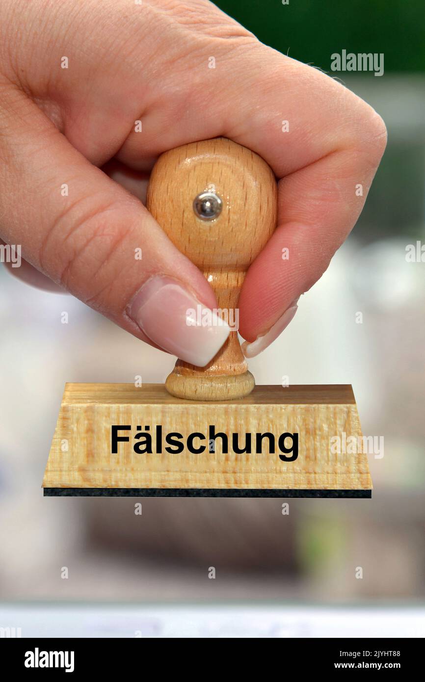 Mano della donna con la scritta del francobollo Faelschung, falsificazione, Germania Foto Stock