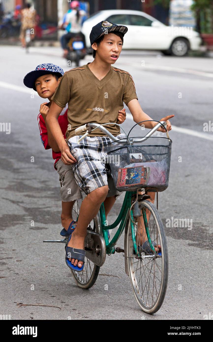 Giovani ciclisti in traffico, Hai Phong, Vietnam Foto Stock