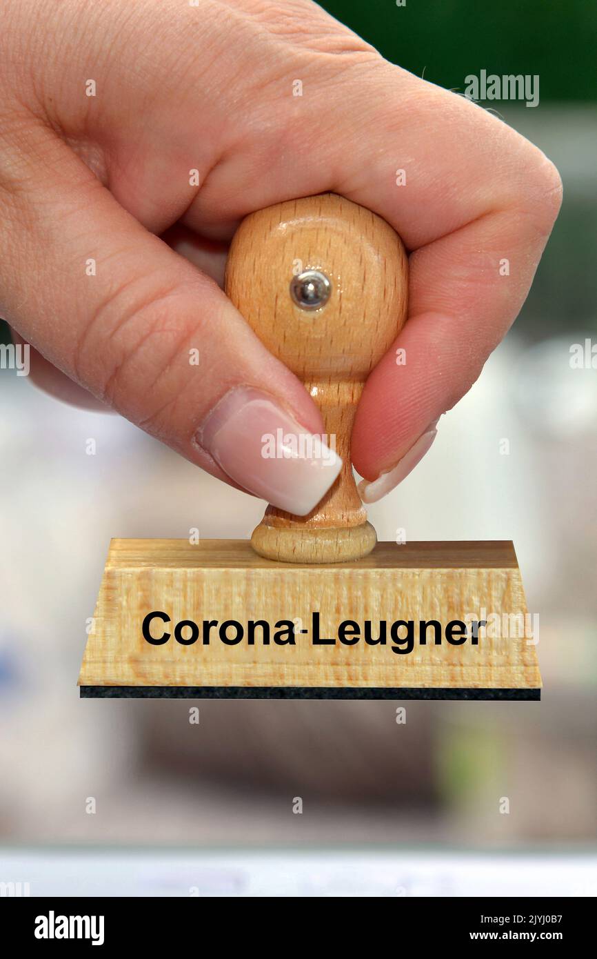 Mano della donna con la scritta del francobollo Corona-Leugner, denier di Corona, Germania Foto Stock