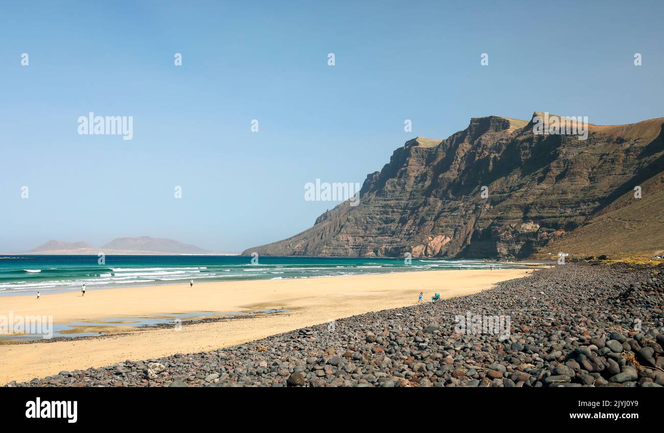 Baia e spiaggia Bahia de Penedo e massiccio del roch Risco de Famara, Isole Canarie, Lanzarote, Famara Foto Stock