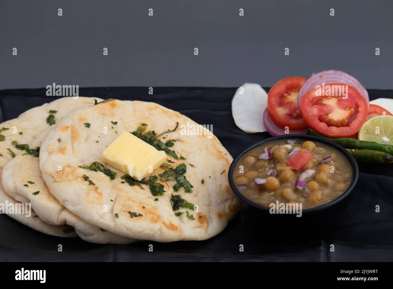 Chole Kulche chiamato anche Matar Kulcha, Chhole Kulche è ampiamente popolare Delhi Street Food. Il piatto è composto da un soffice e soffice pane tostato leggermente lievitato Foto Stock