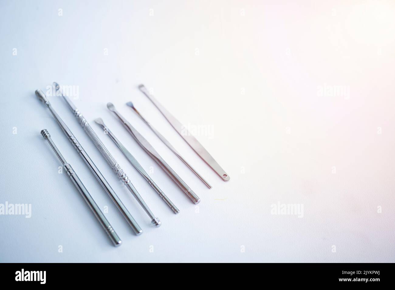 Set di utensili per la pulizia delle orecchie isolate su sfondo bianco. Set di utensili per la pulizia delle orecchie in acciaio inox. Foto Stock