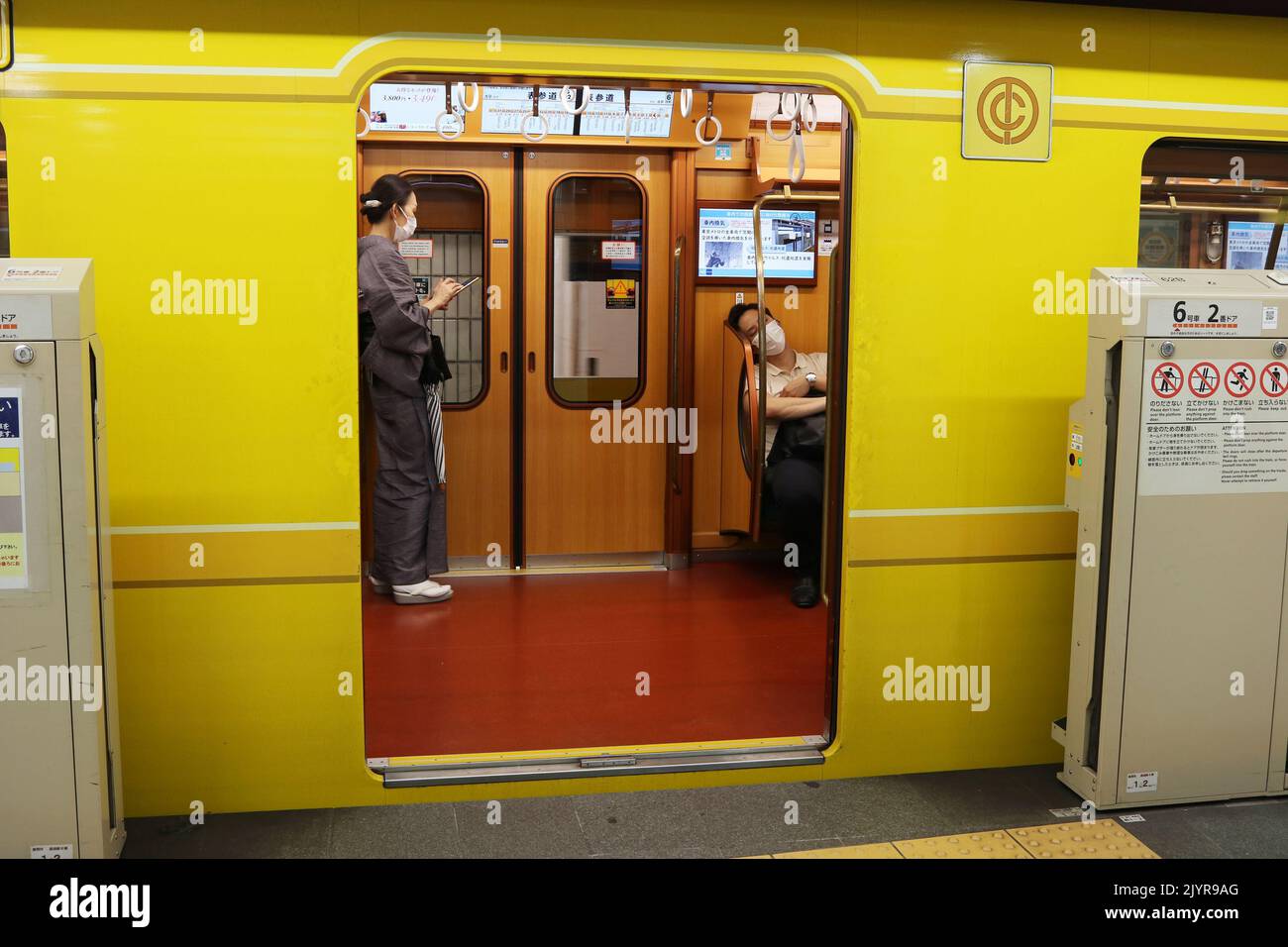 TOKYO, GIAPPONE - 25 agosto 2022: Un treno metropolitano in stile retrò della linea Ginza Tokyo Metro presso una stazione nel centro di Tokyo. Gli sportelli della protezione della piattaforma sono aperti. Foto Stock