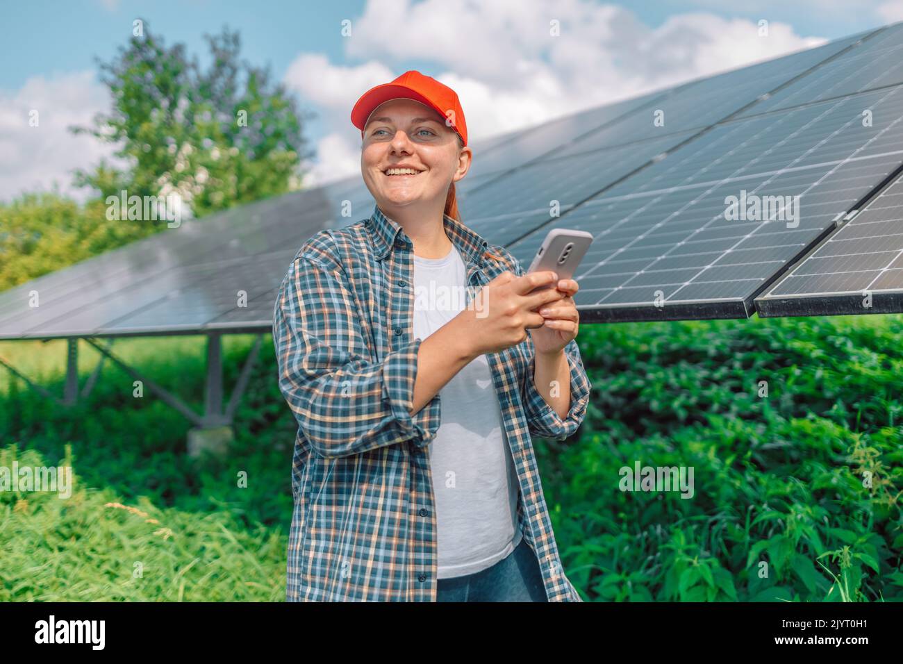 Persona che controlla la generazione di energia solare di pannelli solari per l'installazione domestica in un'app per smartphone. Foto Stock